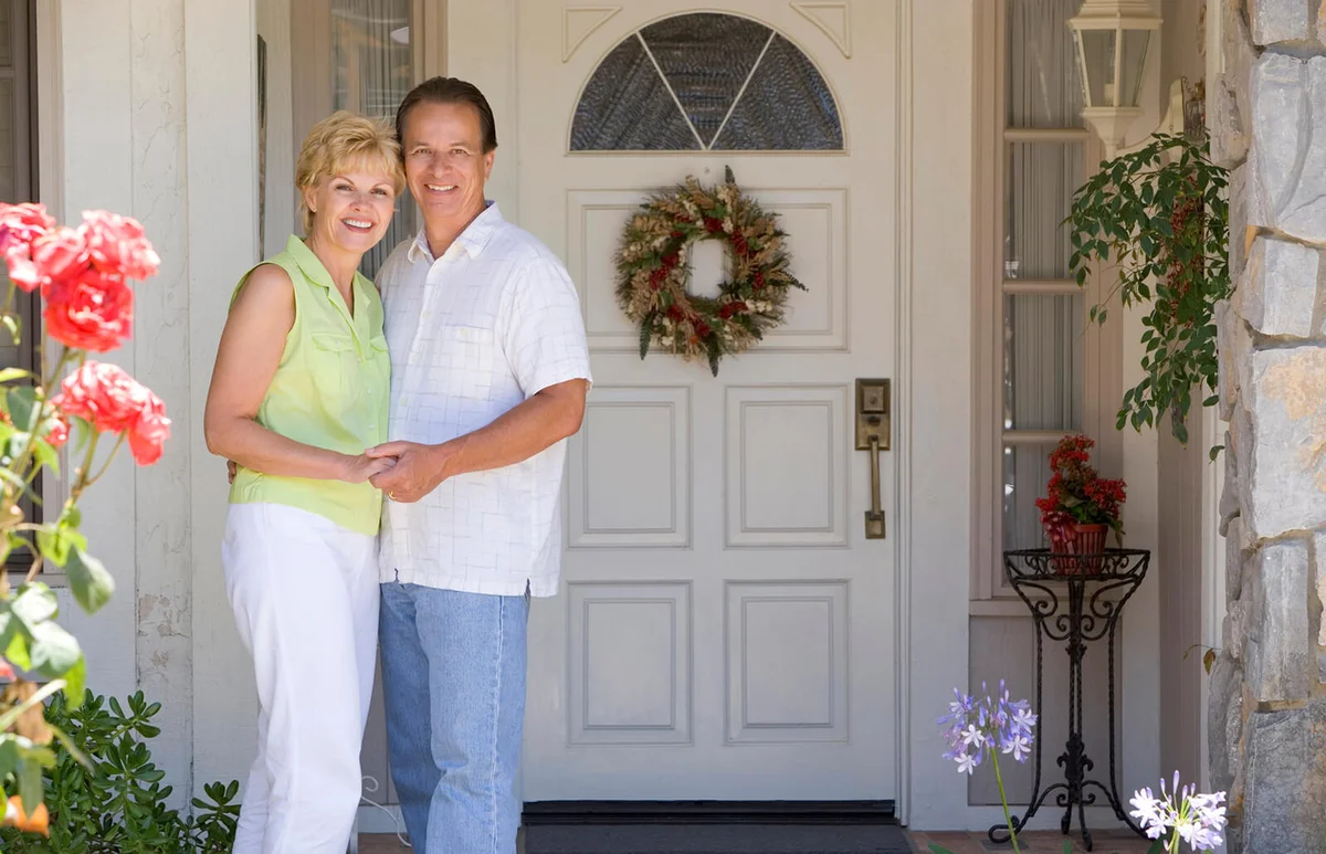 Couple Standing Outside Their House
