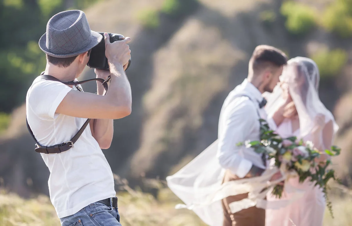wedding photographer takes pictures of the bride and groom in nature