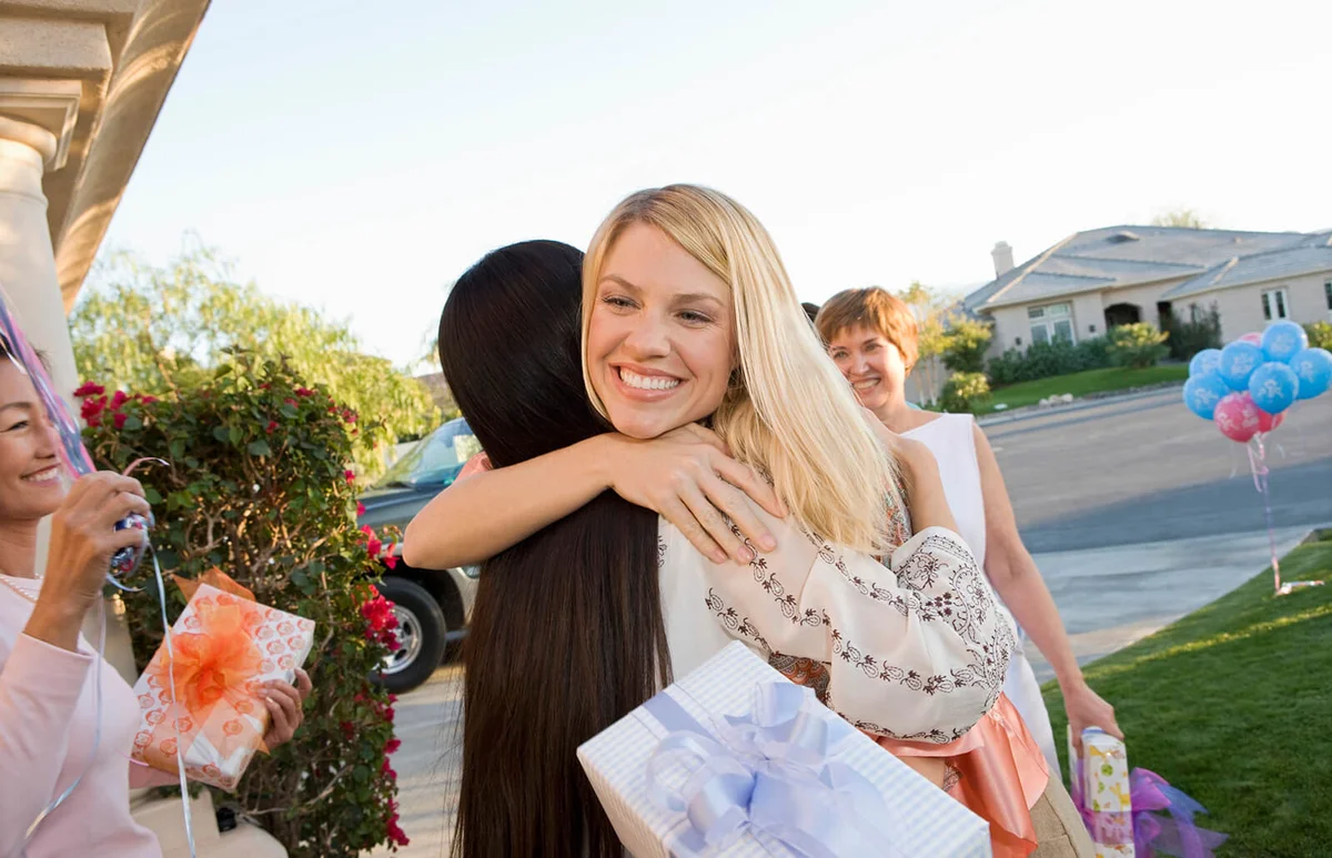 Pregnant Woman embracing Friend at a Baby Shower