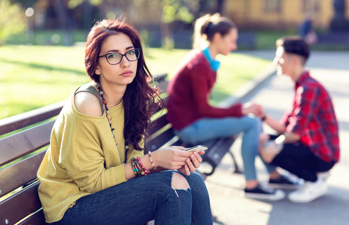 woman looking at camera and ignoring one happy couple