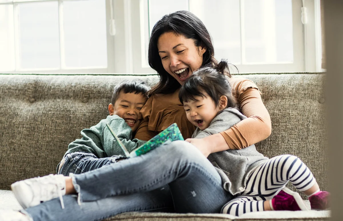 Mother reading to kids on couch