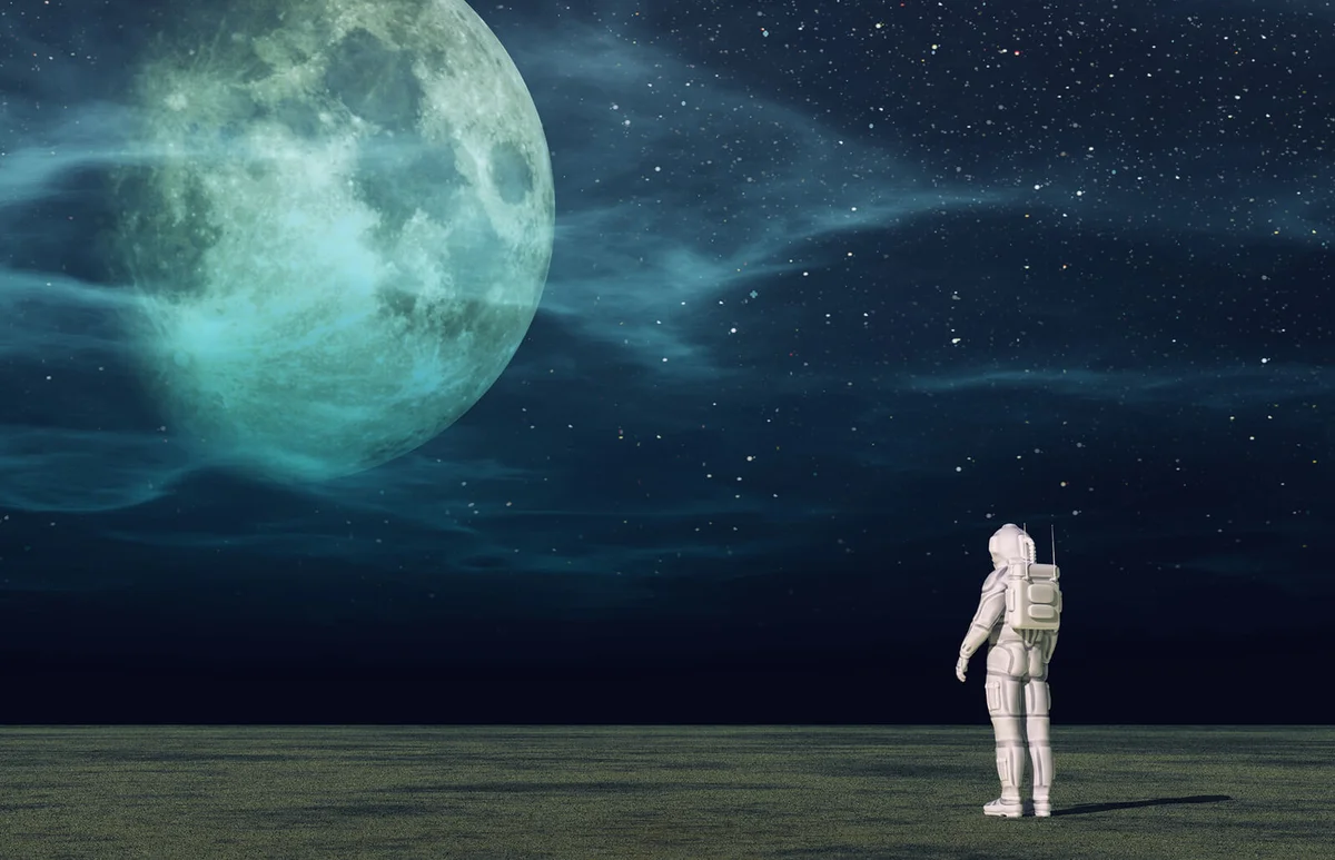 Astronaut standing on a planet and looks to the moon