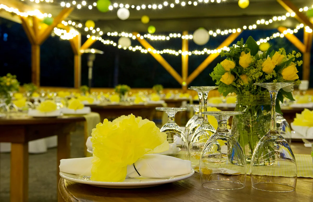 Night time wedding with yellow flowers and strings of light