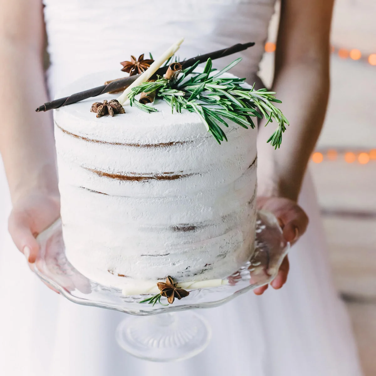 bride holding a craft cake on a glass stand