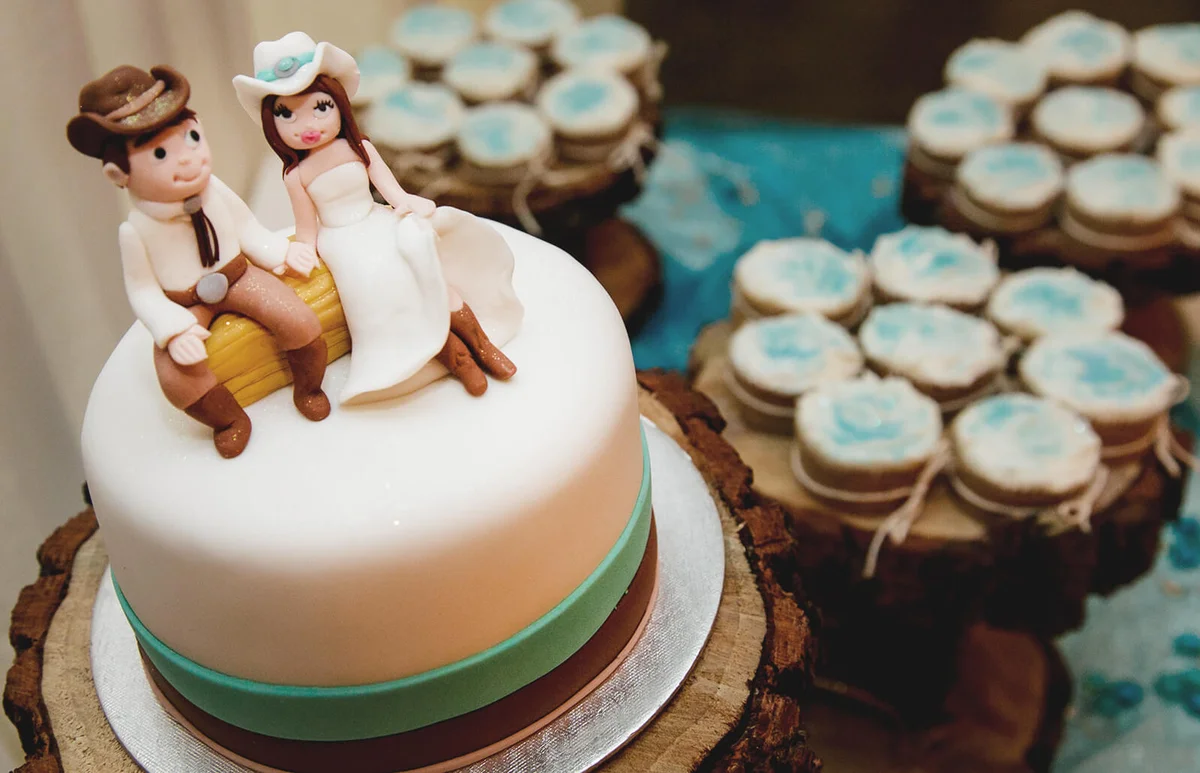 Cowboy wedding cake toppers on a cake at a wedding