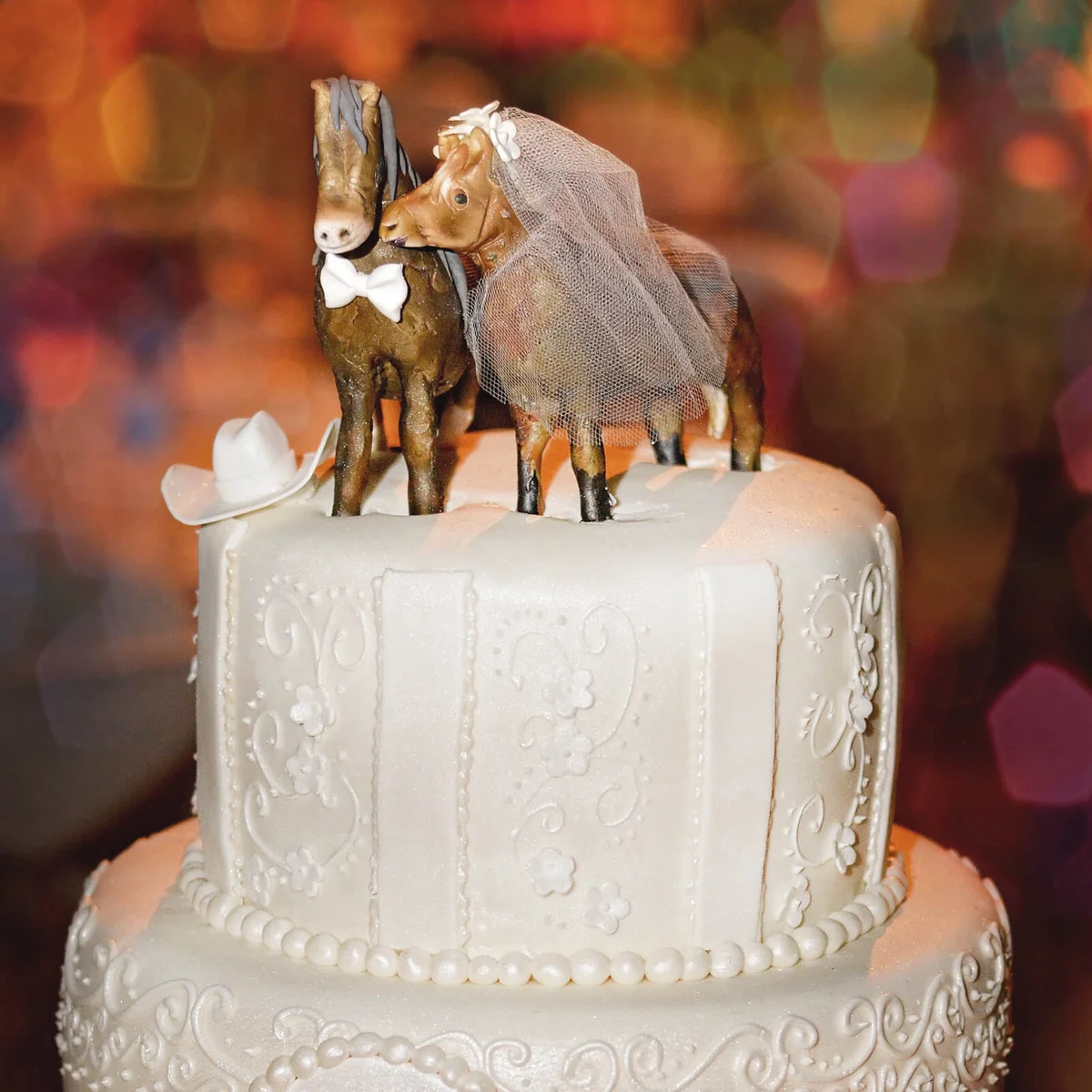 Wedding cake with bride and groom horse toppers