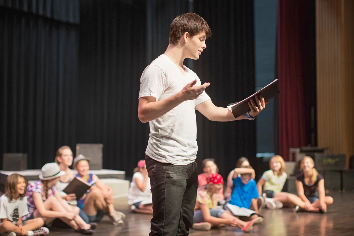 Students practicing lines on stage