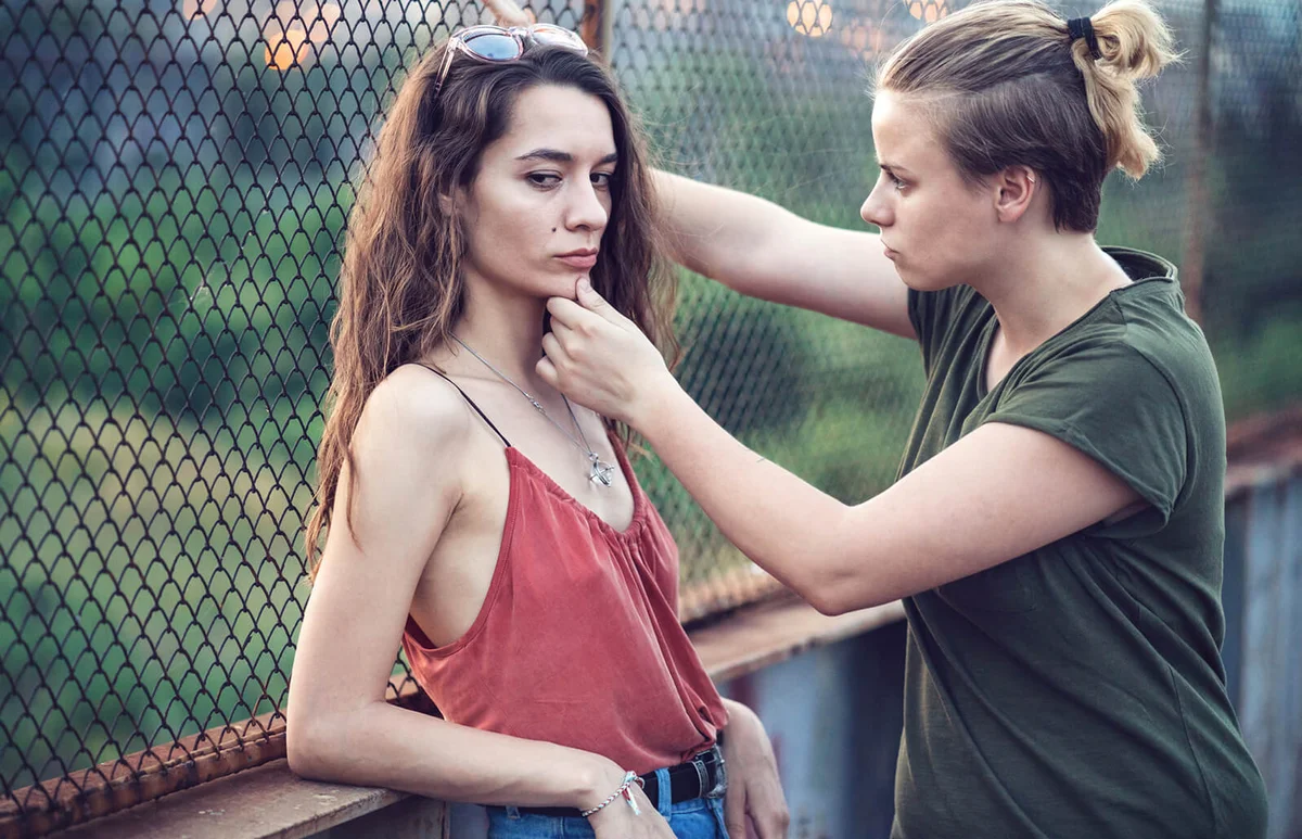 Young low-spirited couple talking on the bridge