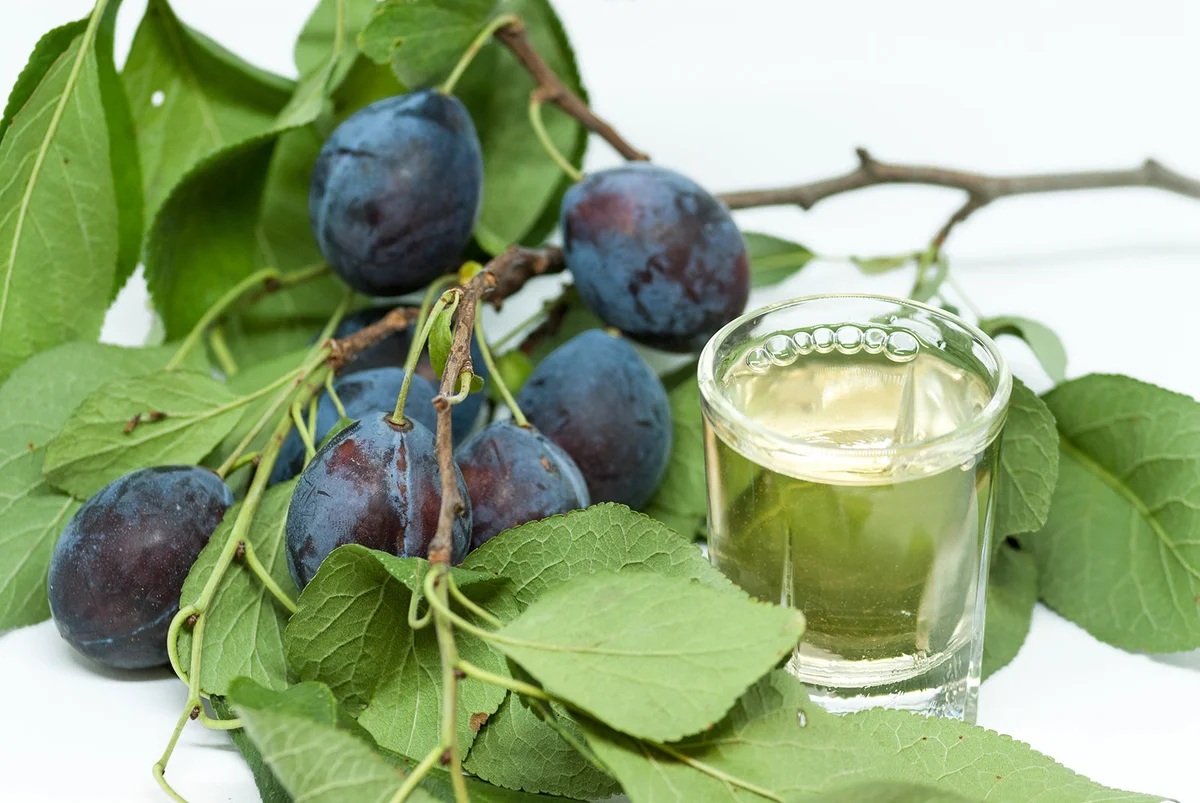 Plums with glass of plum brandy
