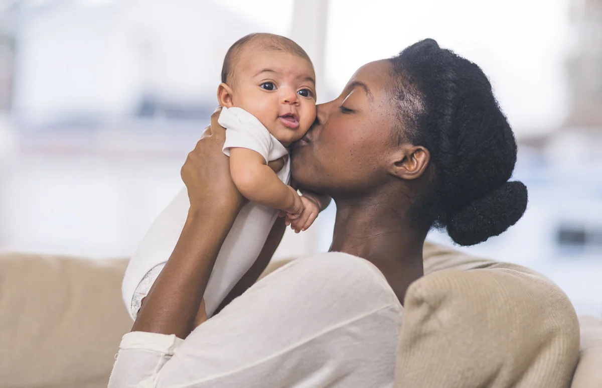 Mother kisses baby's cheek