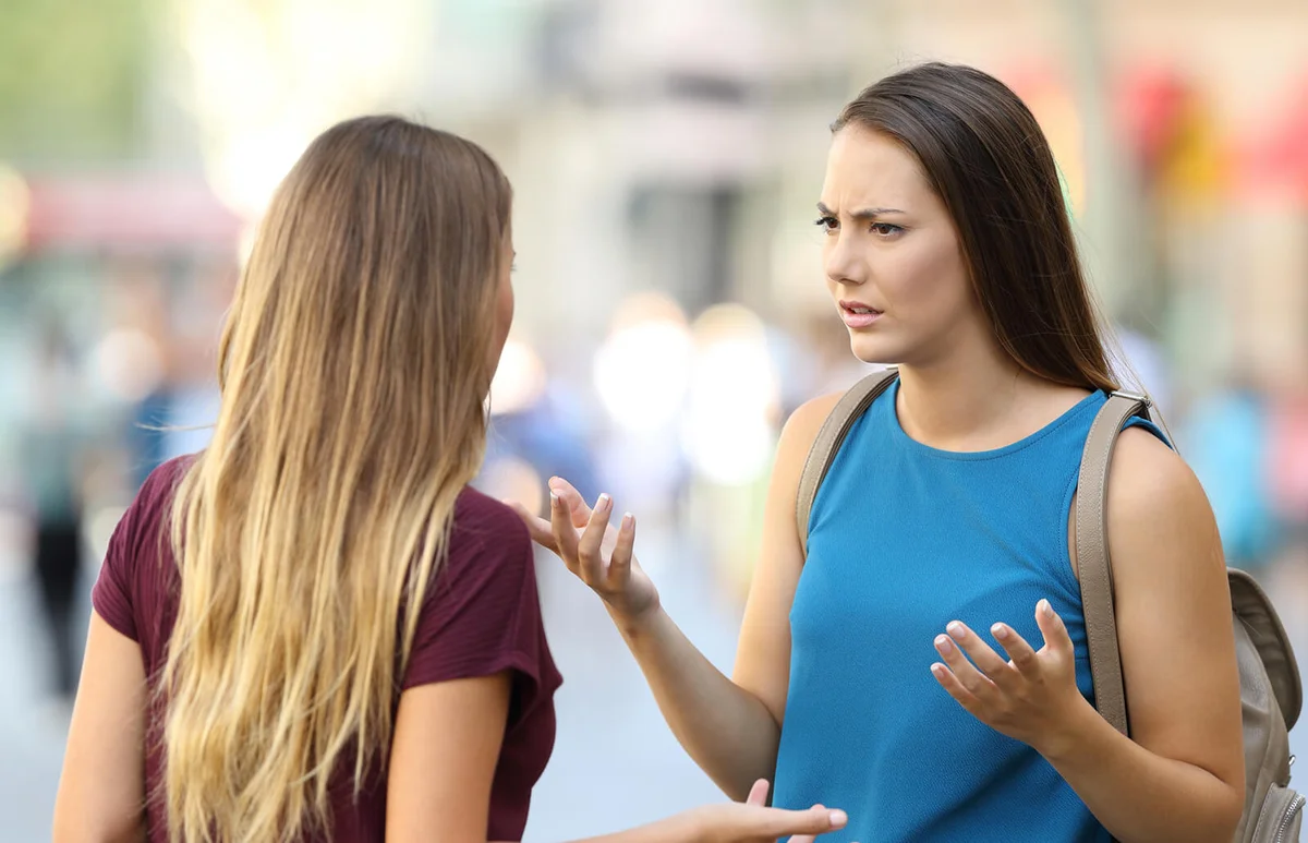 Two friends talking seriously on the street