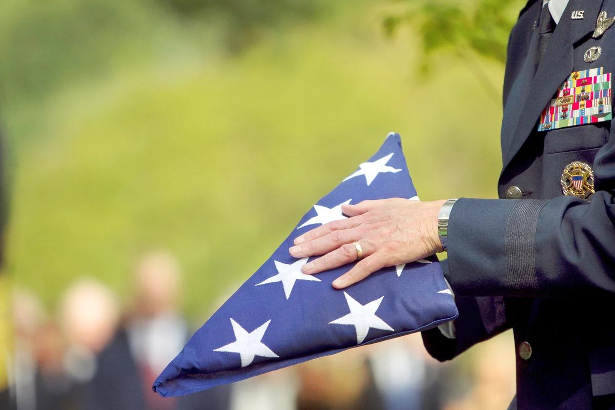Soldier folding flag at military funeral