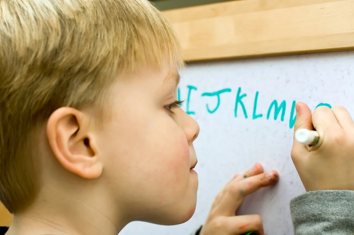 kid writing alphabet