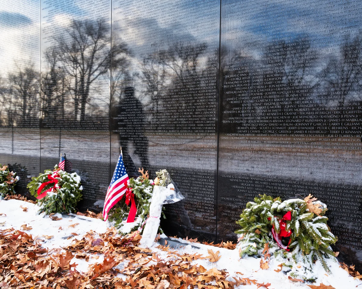 Vietnam Memorial with flags and wreaths and remaining snow
