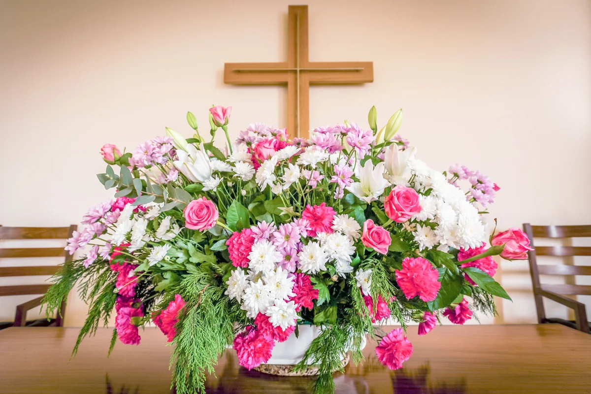 Christian cross and flowers on altar