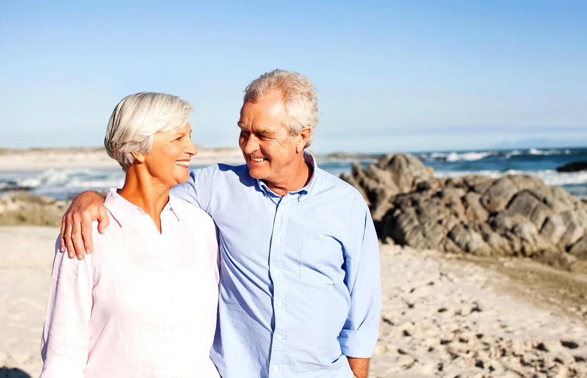 Senior Couple Walking On Beach
