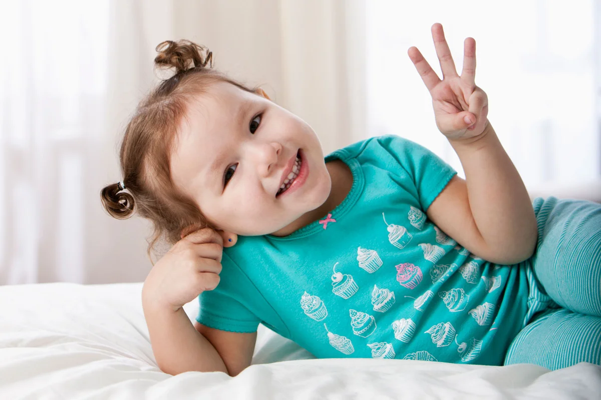 Hispanic girl holding up three fingers