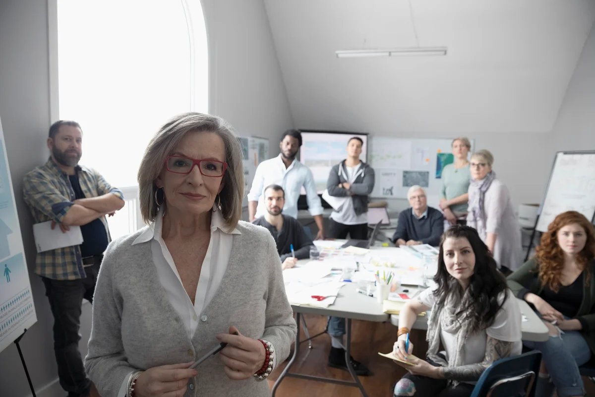 older woman at work with her team