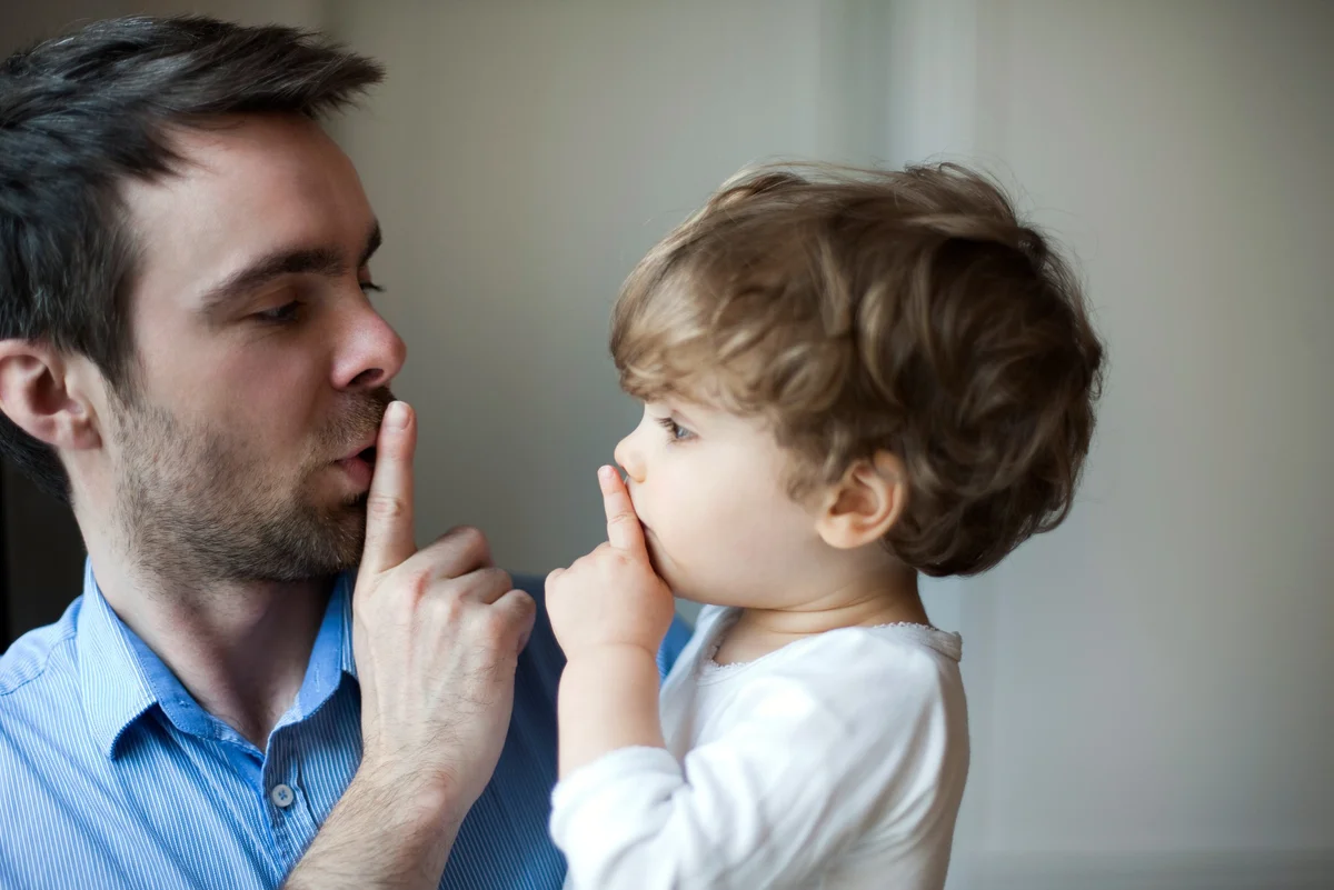 father teaching son to shhhh