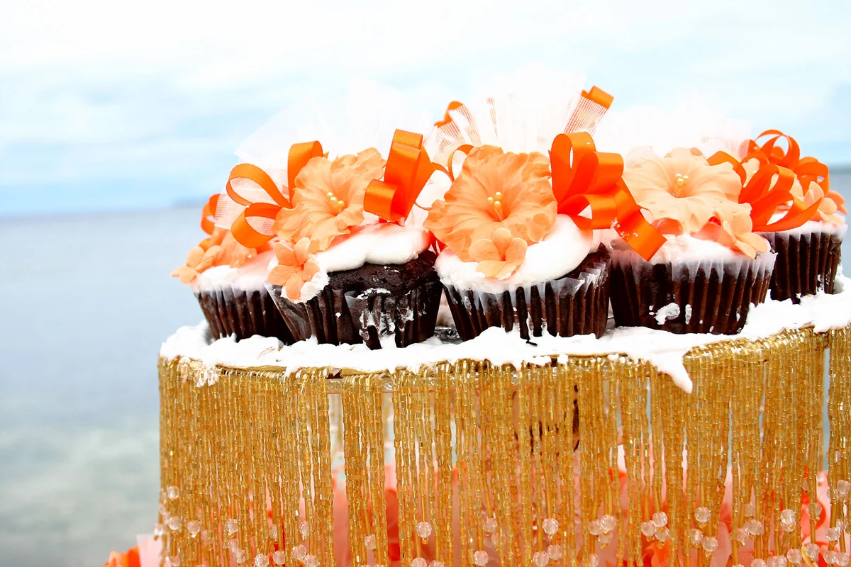 Tropical flower wedding cupcakes by beach
