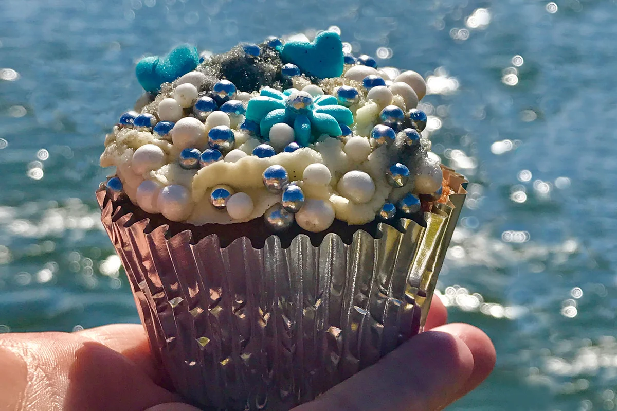 Person holding blue ocean cupcake
