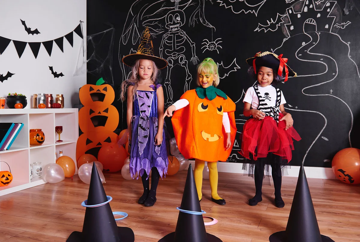 Girls in costumes playing ghoulish ring toss