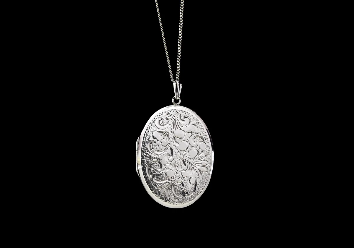 Antique silver locket on black background
