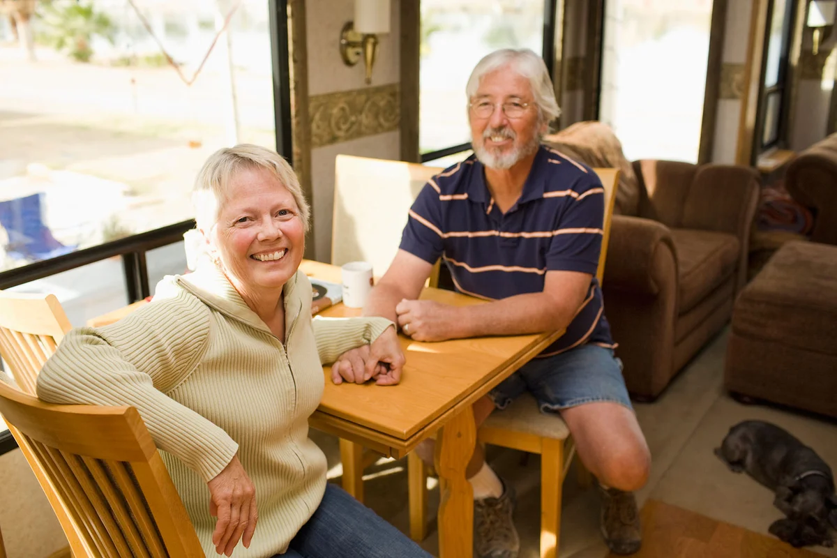Smiling senior couple sitting in motorhome