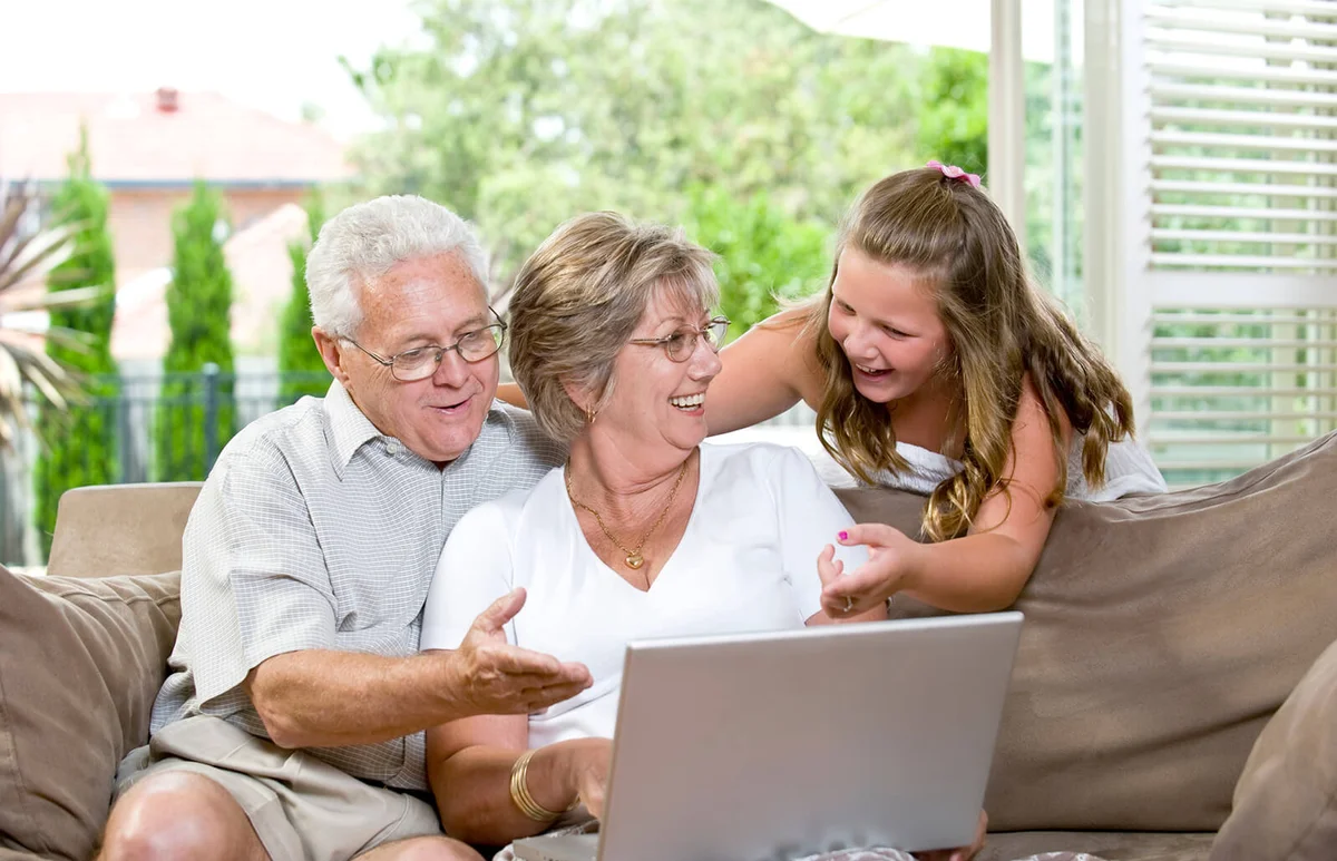 Grandparents and their grandaughter with a computer