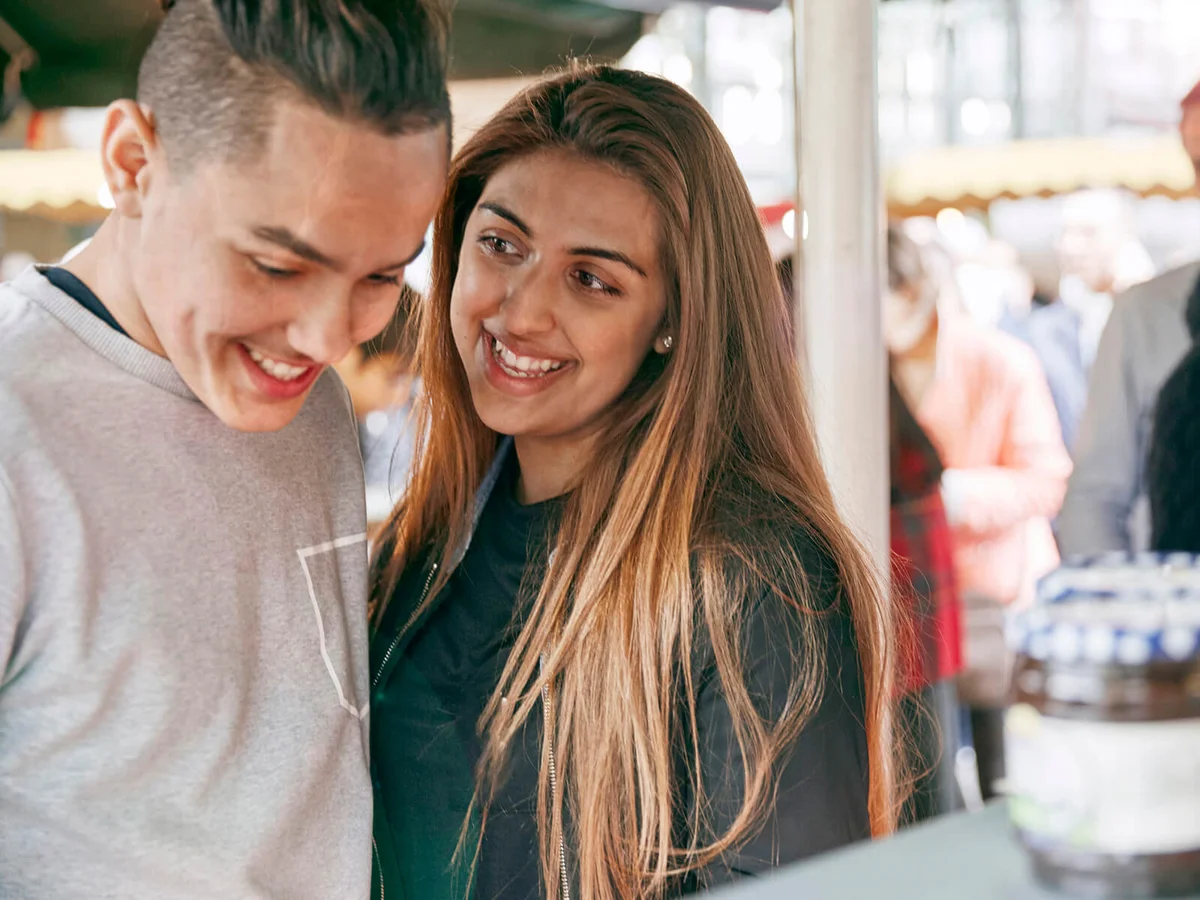 Smiling teenage couple at street market