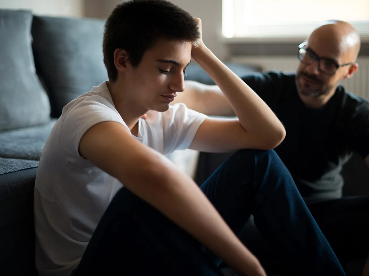 Upset young man talking with his father