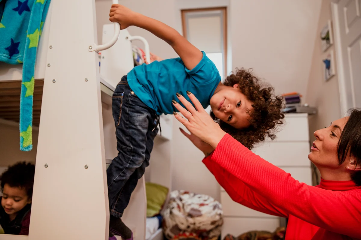 child leaning down with mom ready to catch him