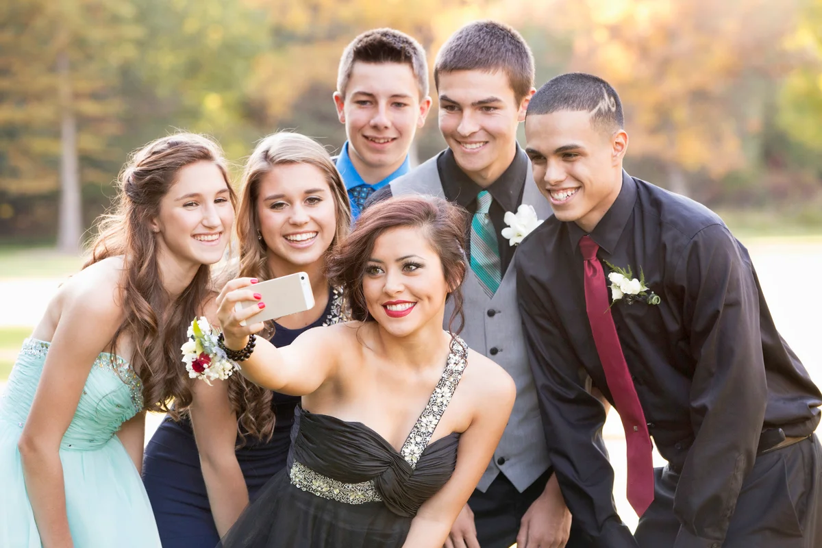 Teenagers taking selfie with cell phone before prom