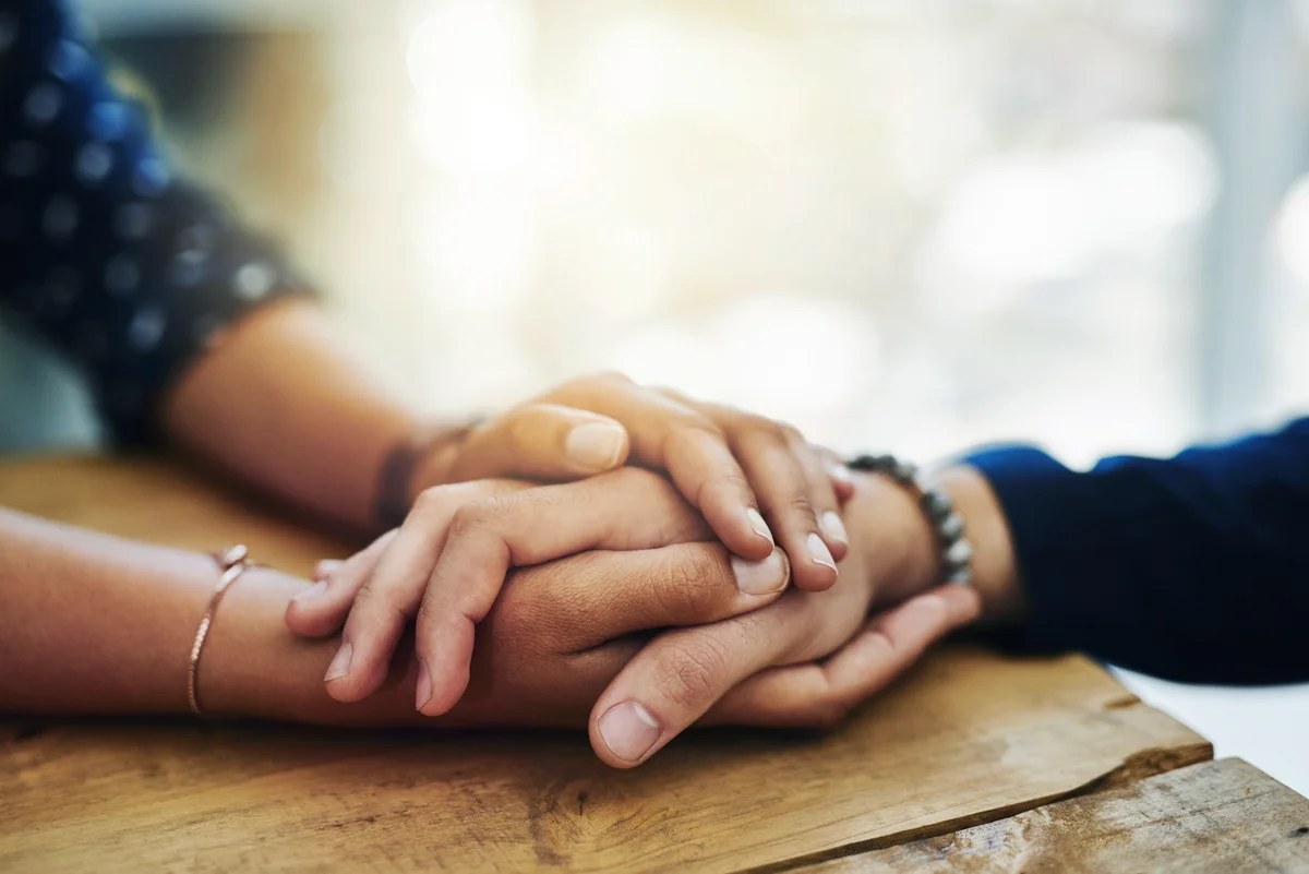 People holding hands in comfort