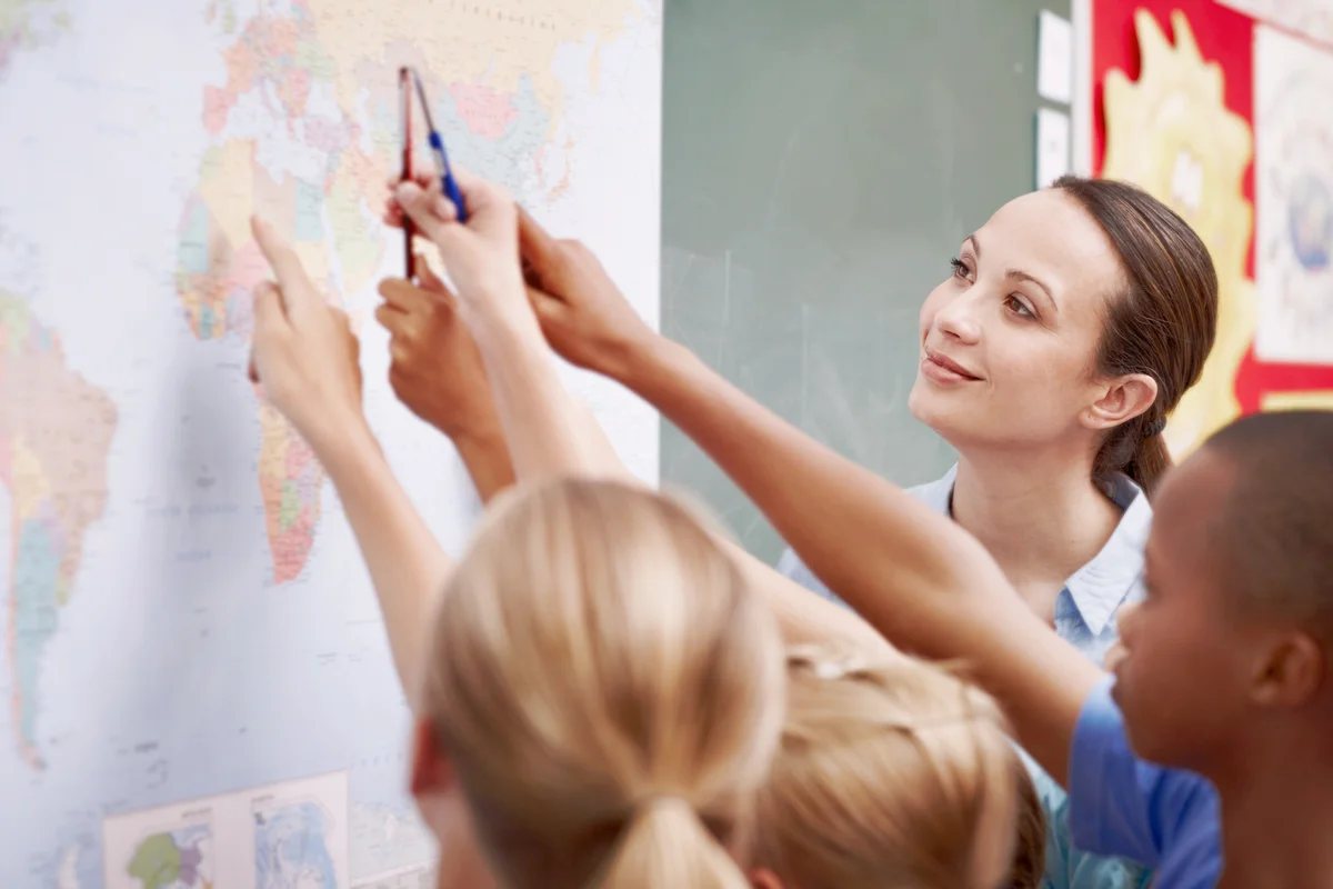 An excited class pointing at a world map