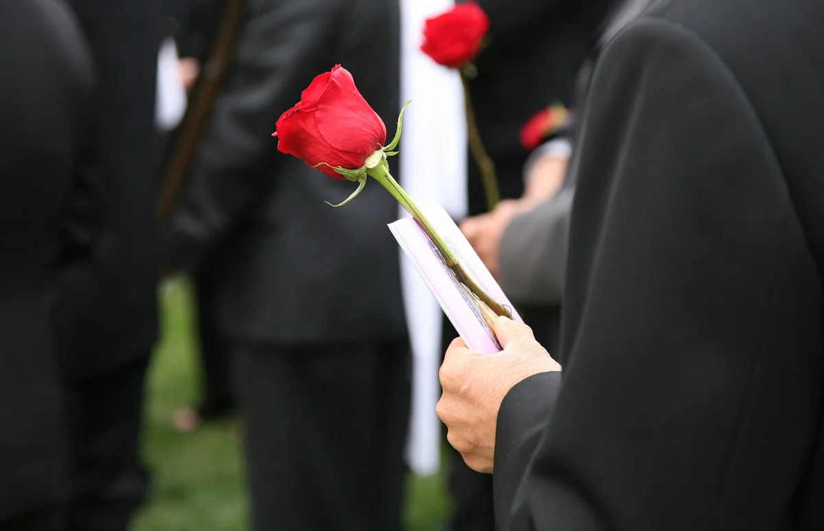 Man holding a funeral program