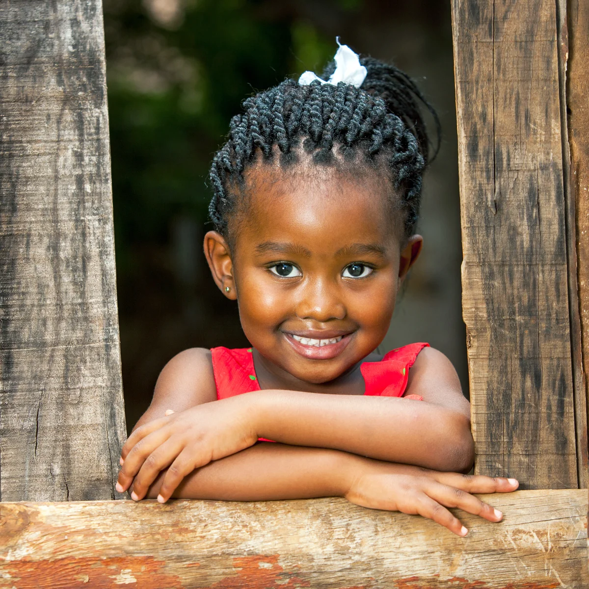 Youngster leaning on wooden fence outdoors