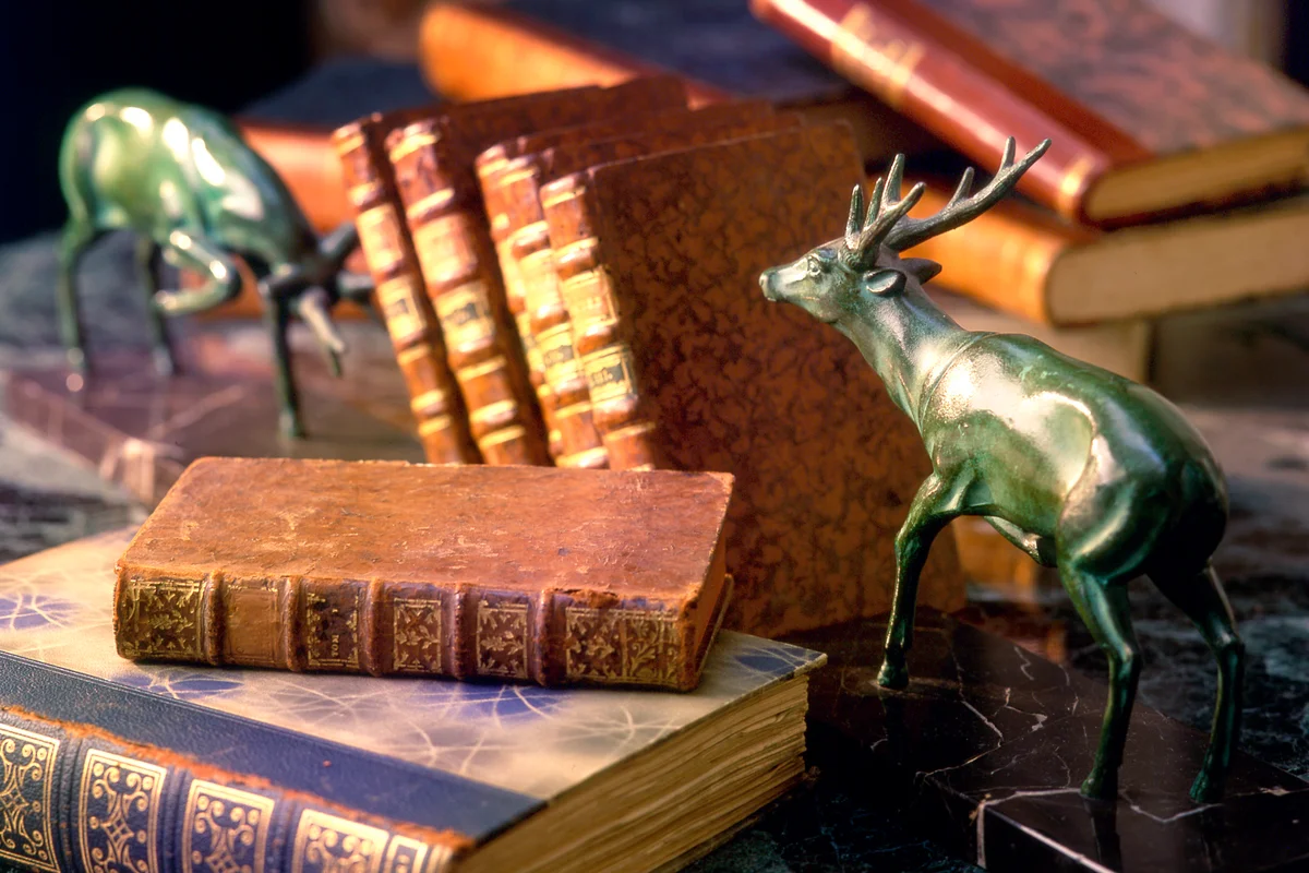 Antique print paper books with two deer bookends