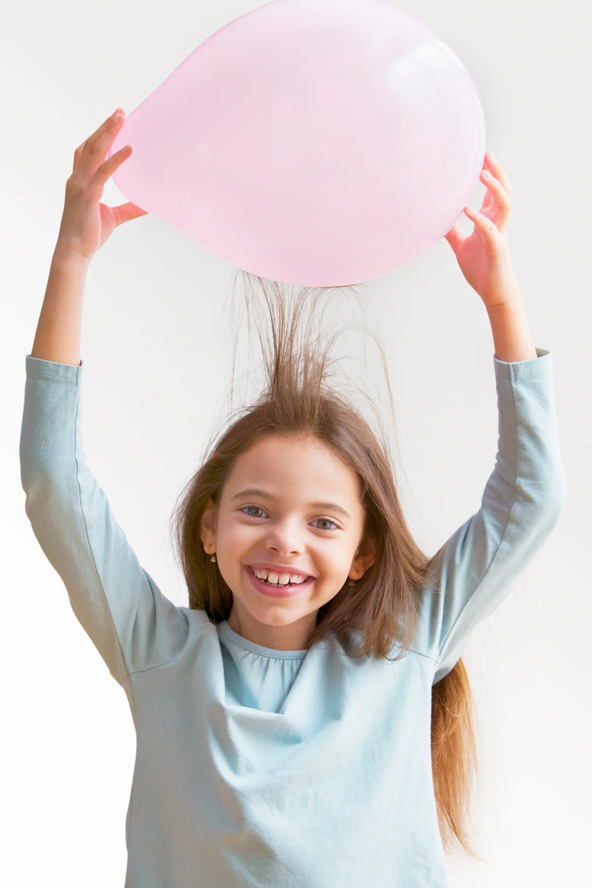 Girl creating static in hair with balloon