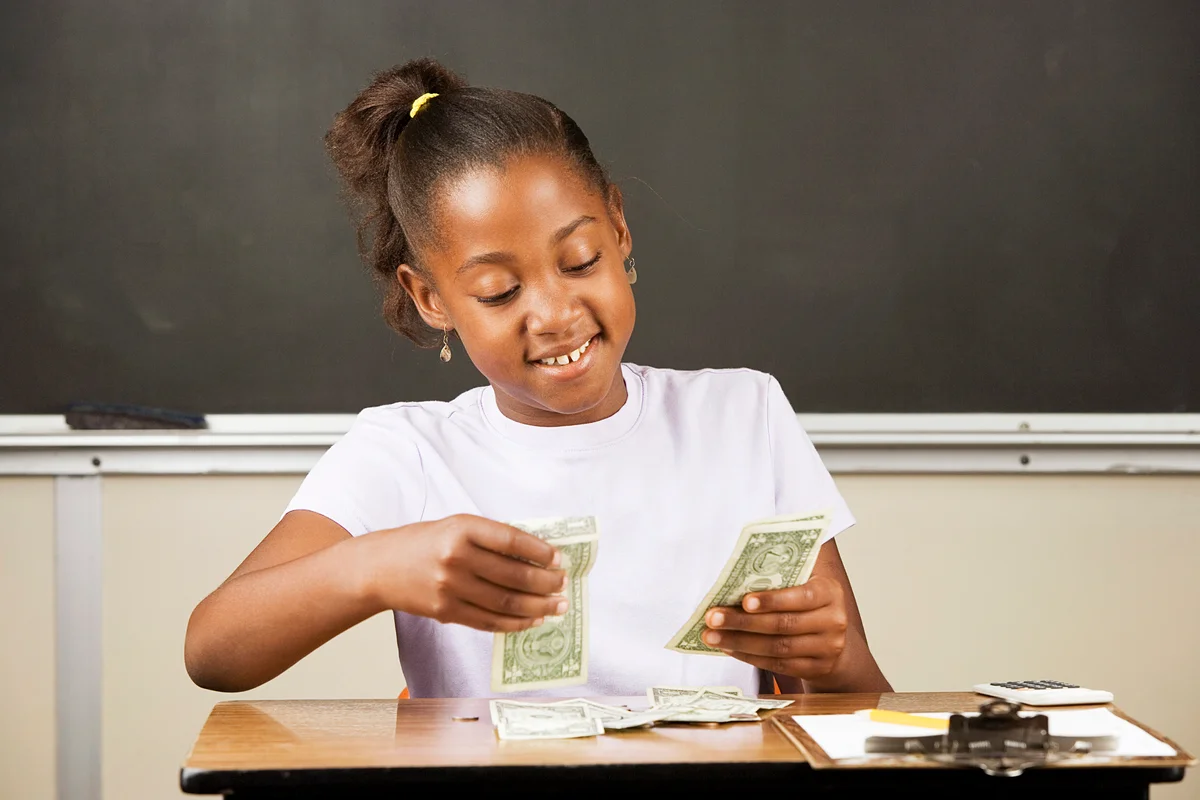 Student counting money on a desk