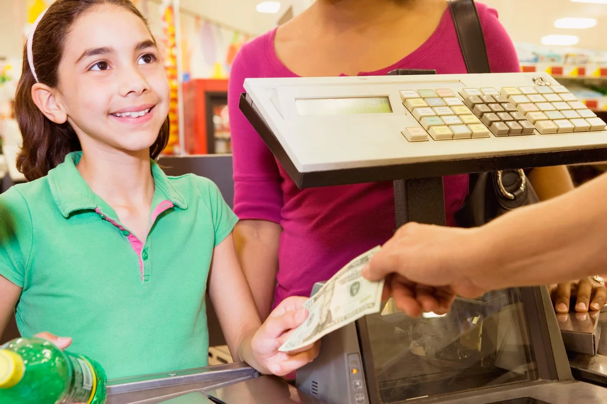 Young Shopper Giving Money to the Cashier
