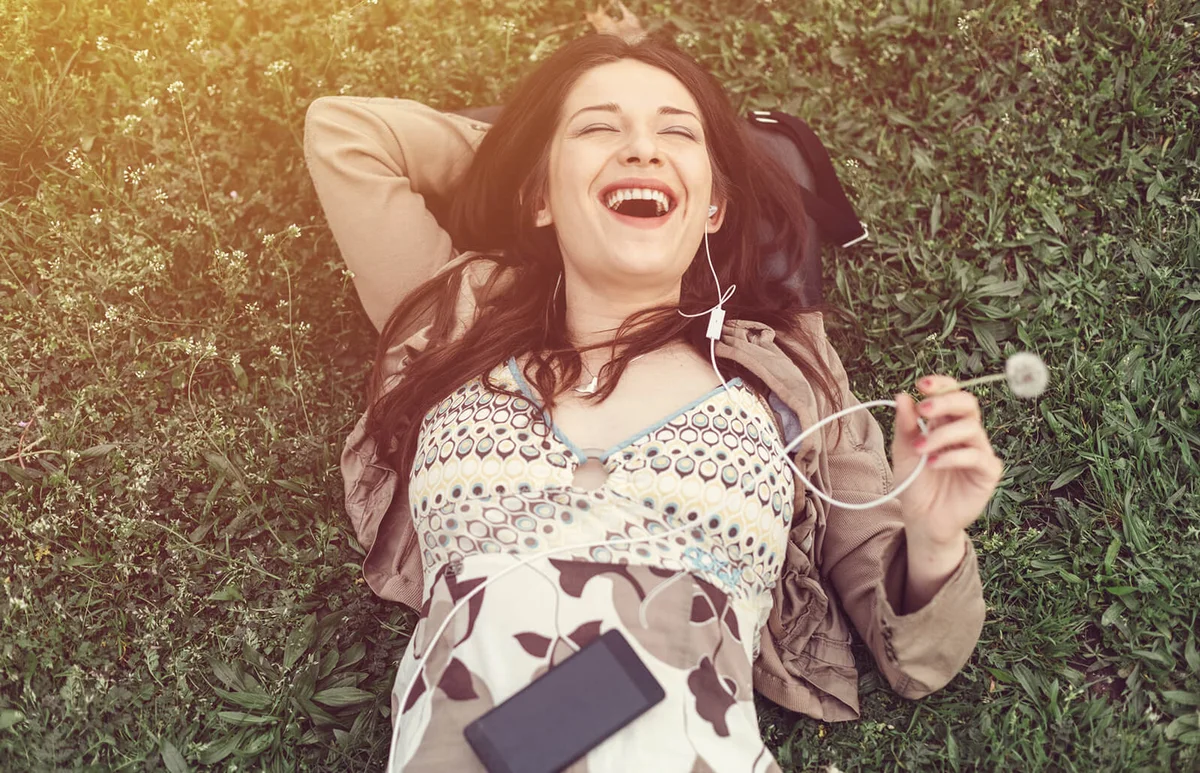 Girl lying down in the grass and singing