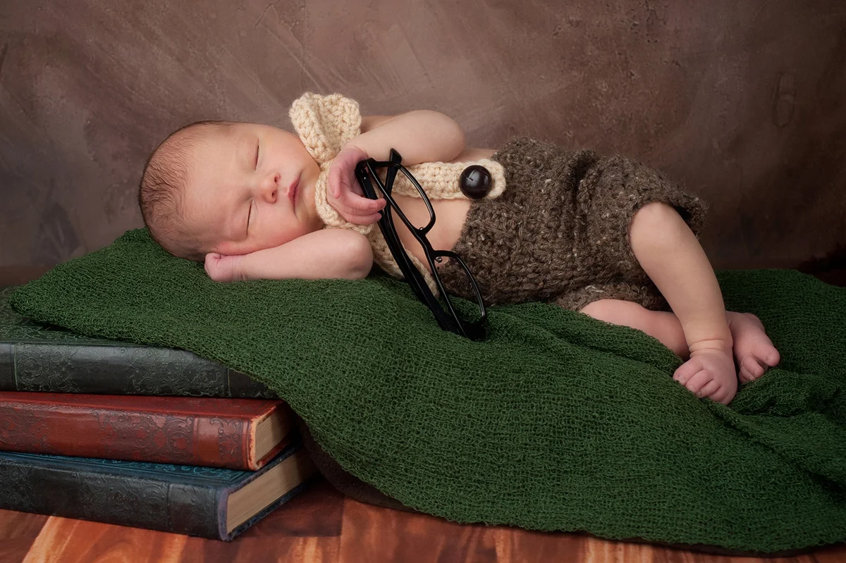 Baby sleeping on literature books