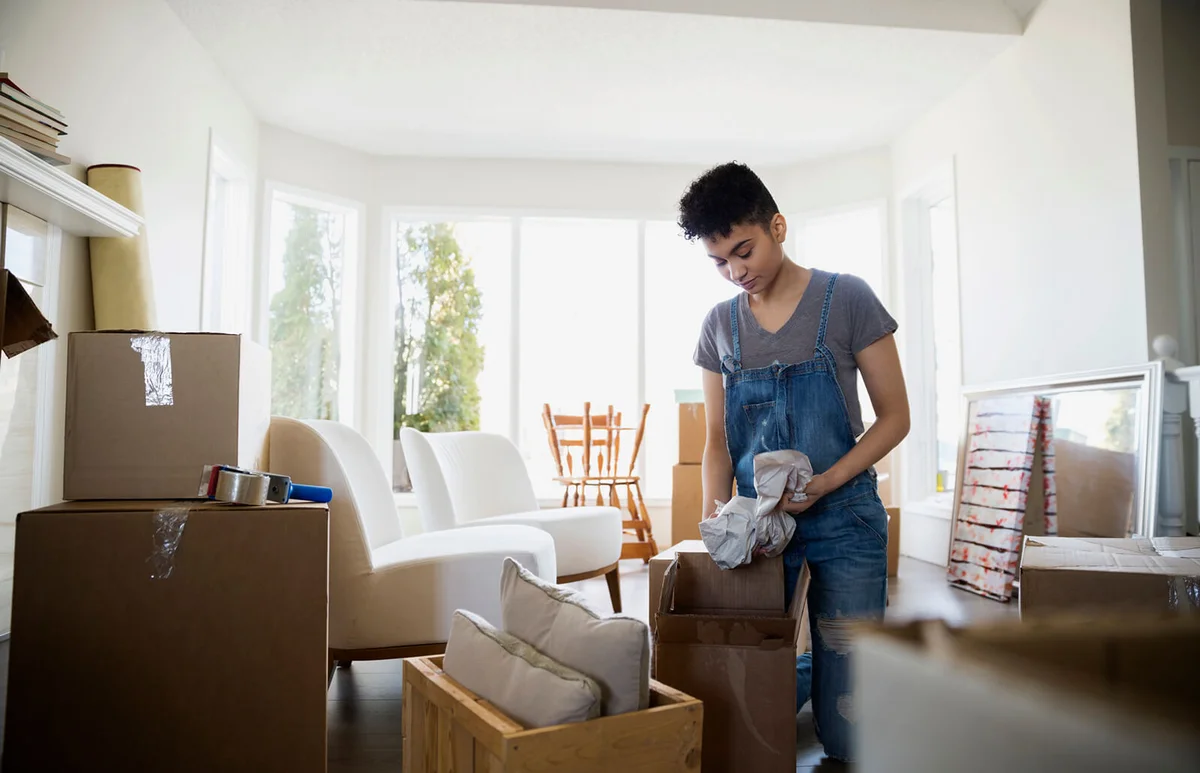 Woman packing belongings in moving boxes