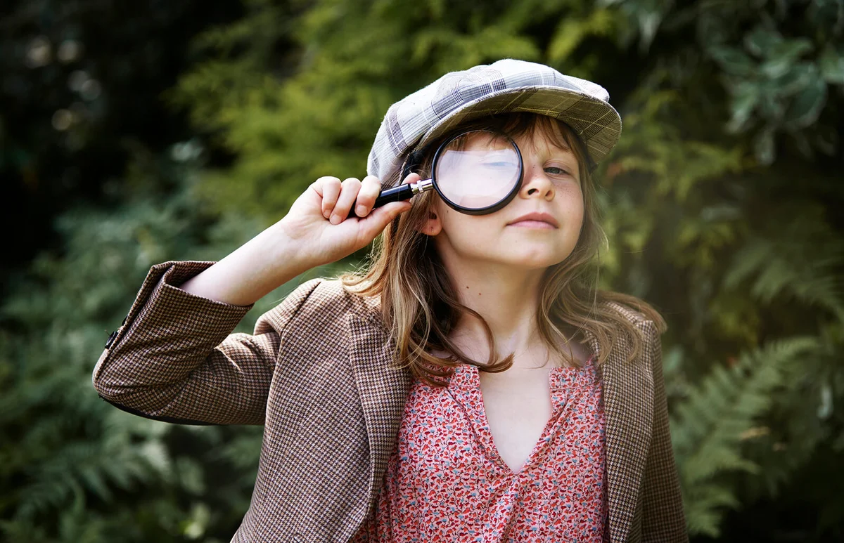 girl looking through magnifying glass