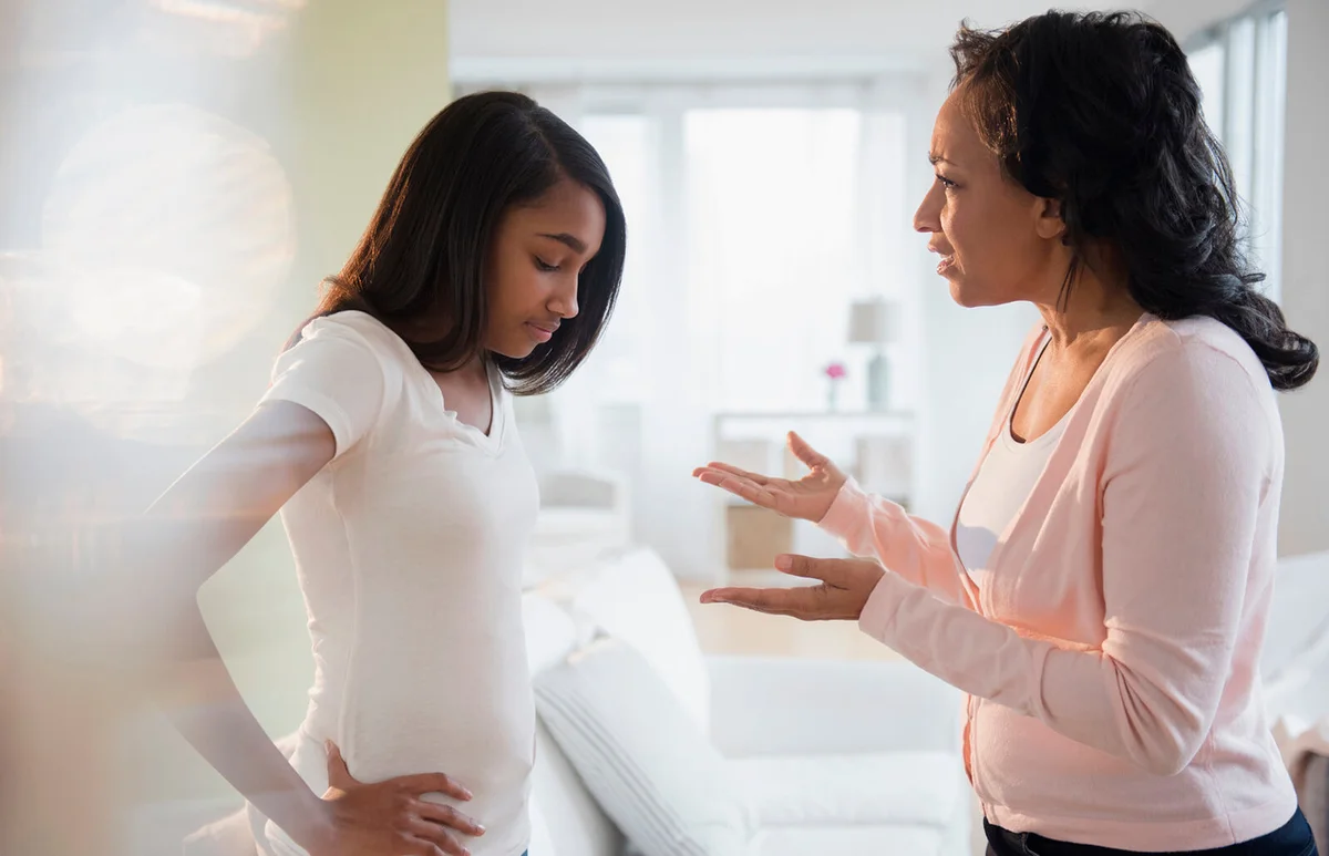 Mother scolding frustrated daughter