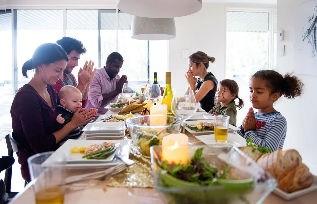 Family praying during thanksgiving dinner