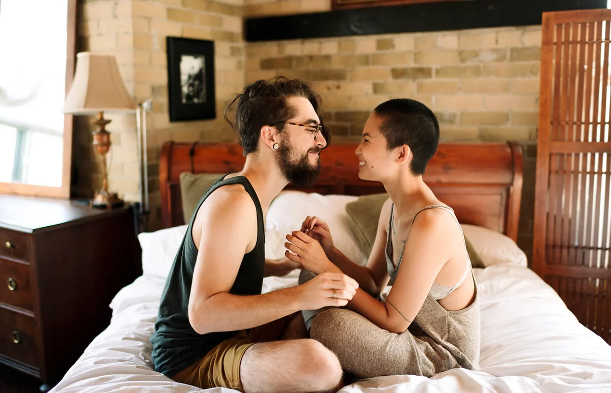 Couple sitting cross legged on bed