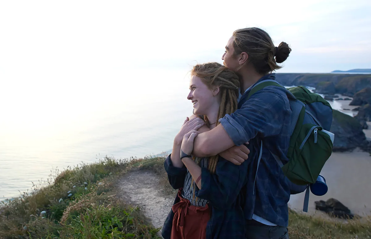 Young hiking couple embrace on Atlantic coastline