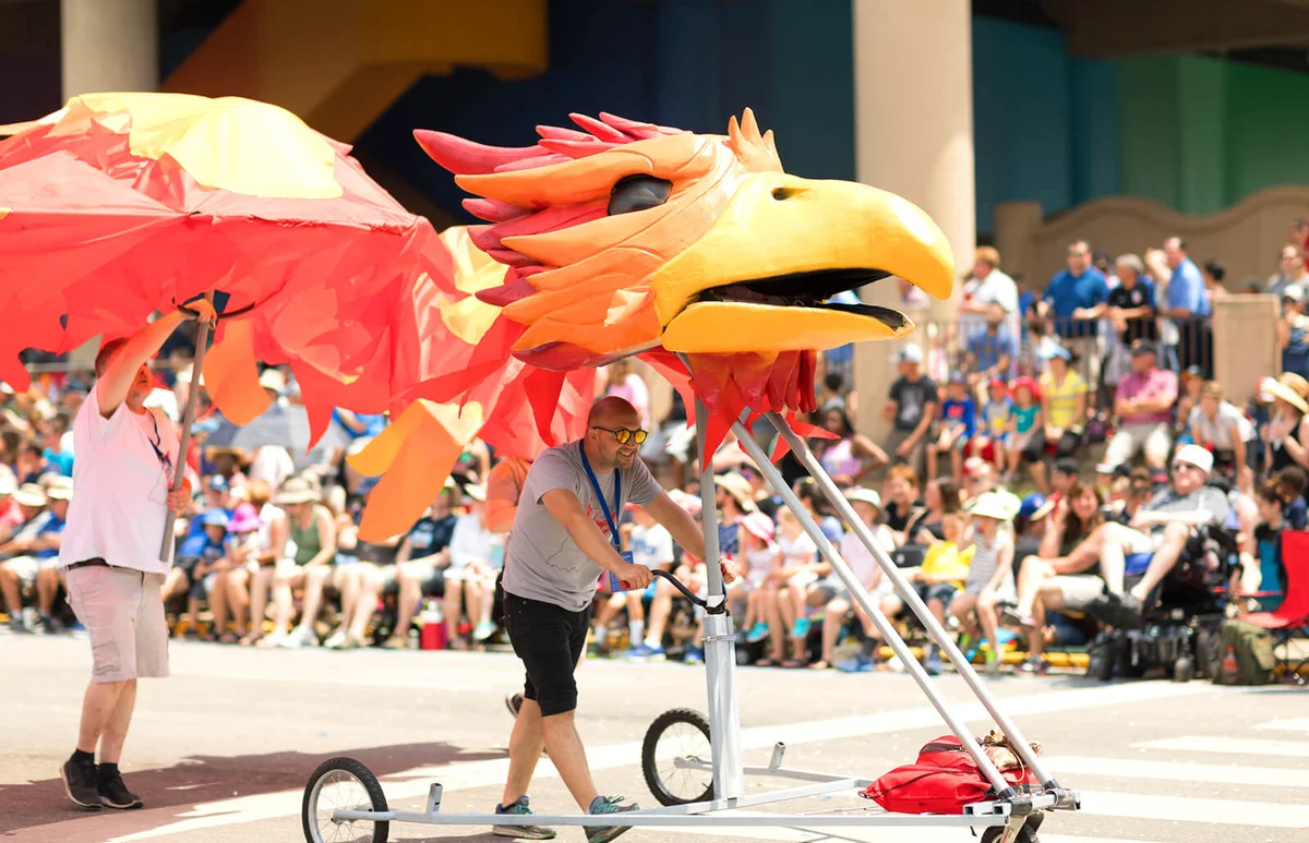 People push a float in shape of a red bird at the Indy 500 Parade | ID 119667890 © Roberto Galan | Dreamstime.com